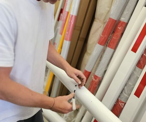 Zaměstnanec kontrolující elektronické čidlo vycházející z ramene parkovací závory
